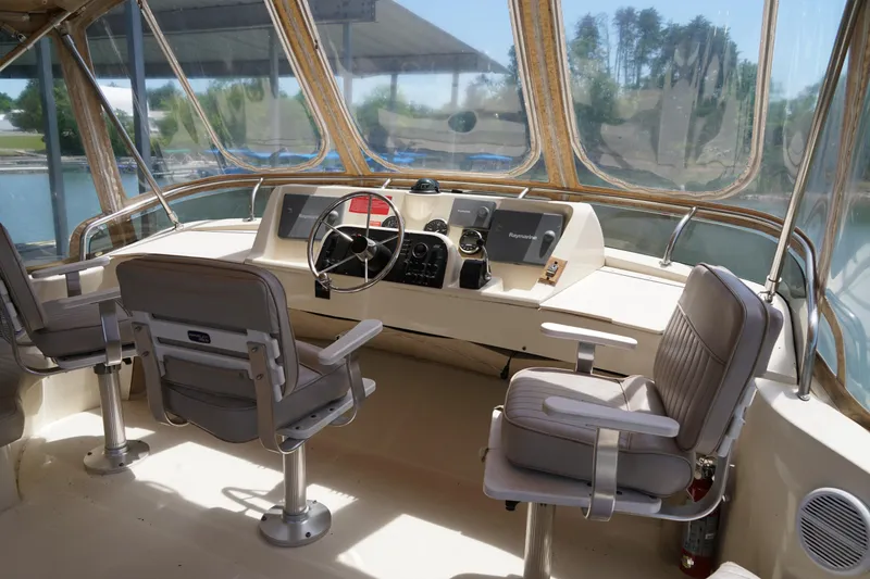 Slide: The Image of Mainship boat helm with dual captain chairs, steering wheel, and navigation equipment. - 27