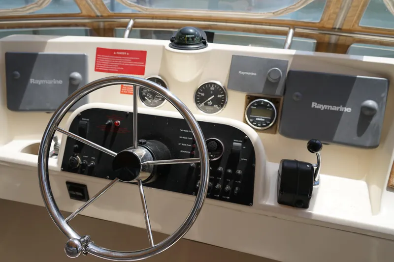 Slide: The Image of Mainship boat helm with Raymarine navigation equipment and steering wheel. - 28
