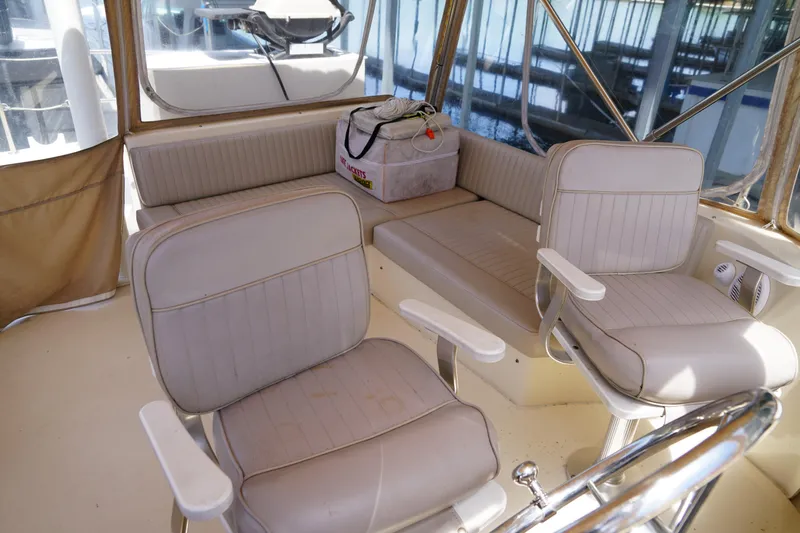 Slide: The Image of Mainship boat interior with beige seating, steering wheel, and storage bag on bench. - 29