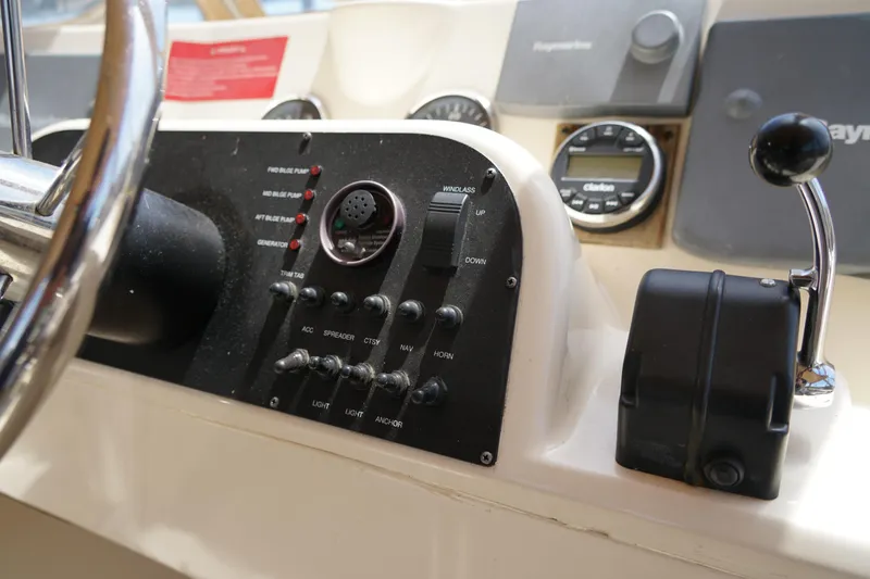 Slide: The Image of Mainship boat control panel with switches, gauges, and steering wheel. - 30
