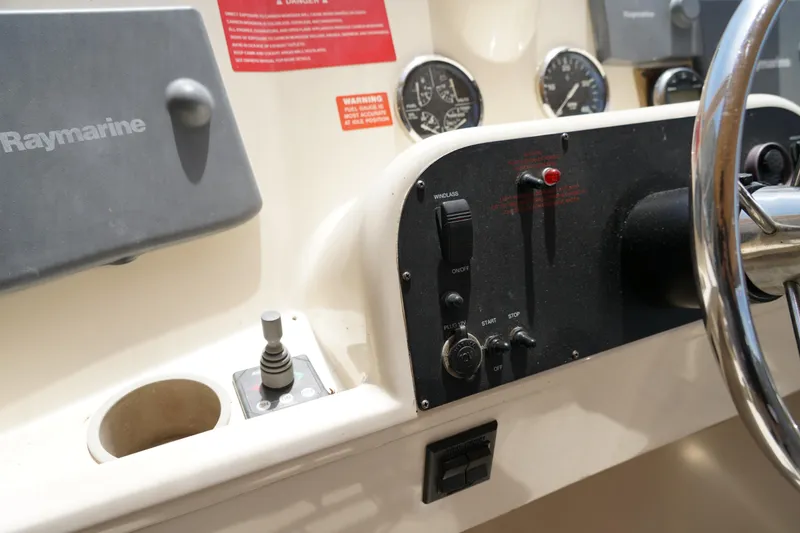 Slide: The Image of Control panel of a Mainship boat featuring Raymarine equipment and steering wheel. - 31