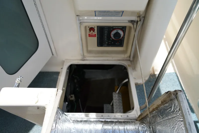 Slide: The Image of Engine compartment access on a Mainship boat with control panel and insulated hatch. - 32