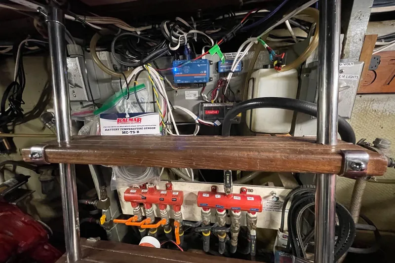 Slide: The Image of Engine room of a 1976 Hatteras 48 Long Range Cruiser with wiring and control panels. - 15