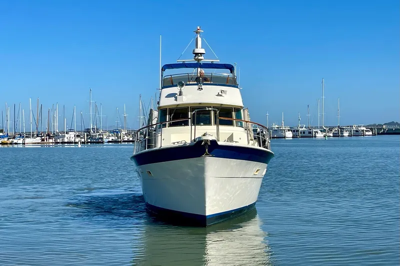 Slide: The Image of 1976 Hatteras 48 Long Range Cruiser in marina, clear blue sky background. - 2