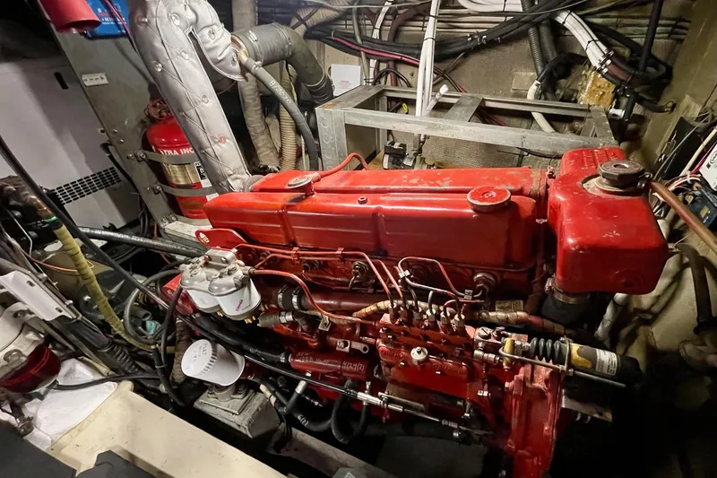 Slide: The Image of Engine room of a 1976 Hatteras 48 Long Range Cruiser with red machinery. - 23