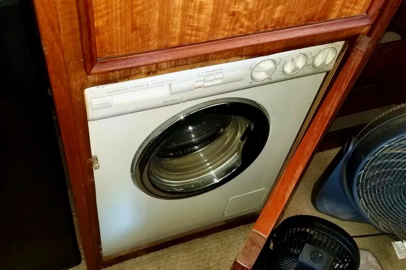 Slide: The Image of Washer-dryer unit in 1976 Hatteras 48 Long Range Cruiser, wooden cabinetry. - 26