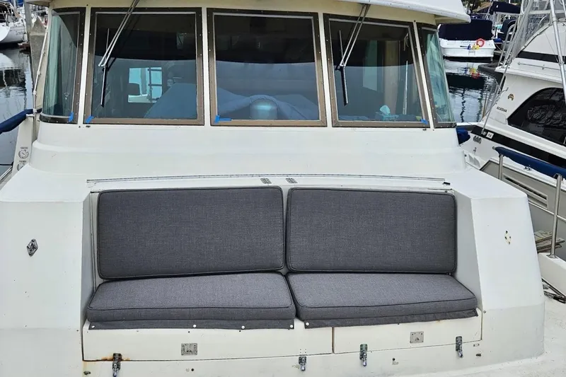Slide: The Image of 1976 Hatteras 48 Long Range Cruiser with gray cushioned seating at the stern. - 28