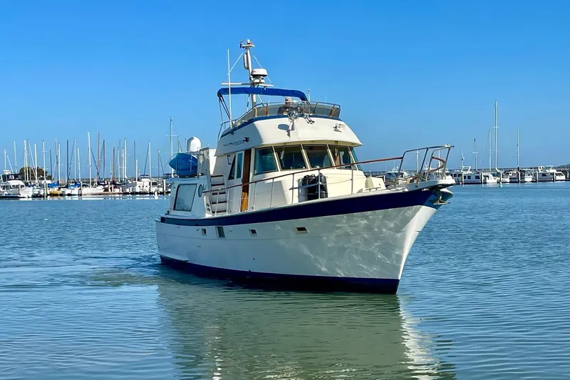 Slide: The Image of 1976 Hatteras 48 Long Range Cruiser in marina, clear blue sky, calm water. - 3