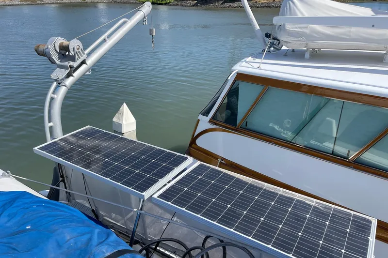 Slide: The Image of 1976 Hatteras 48 Long Range Cruiser with solar panels docked by the water. - 40