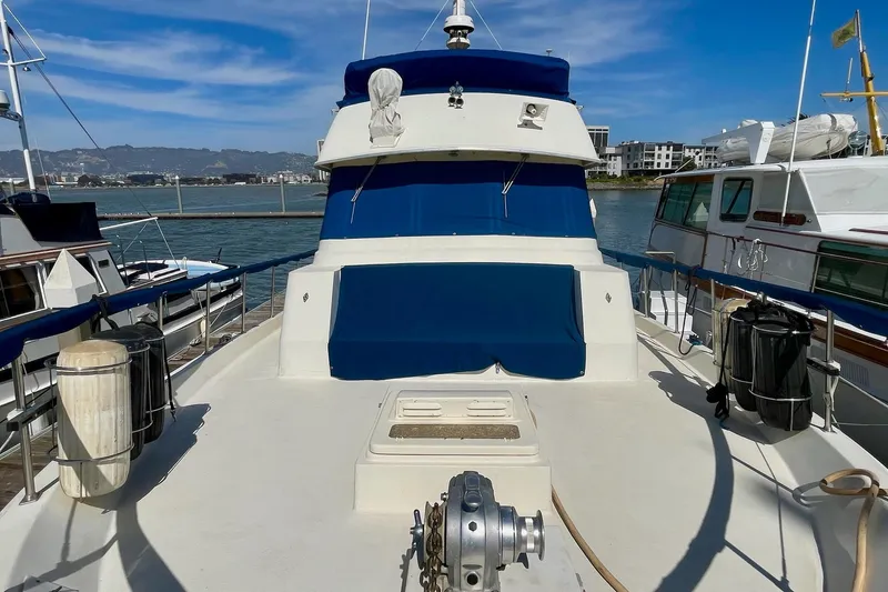 Slide: The Image of 1976 Hatteras 48 Long Range Cruiser docked, featuring blue and white exterior. - 42