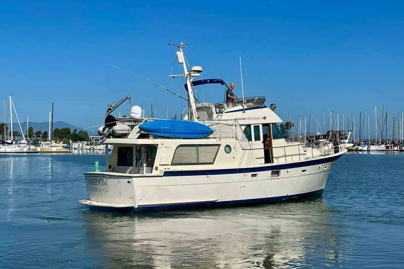 Slide: The Image of 1976 Hatteras 48 Long Range Cruiser yacht in marina, clear blue sky. - 5