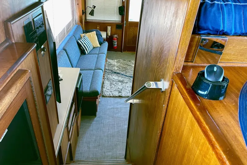 Slide: The Image of Interior of 1976 Hatteras 48 Long Range Cruiser with blue sofa and wooden accents. - 50