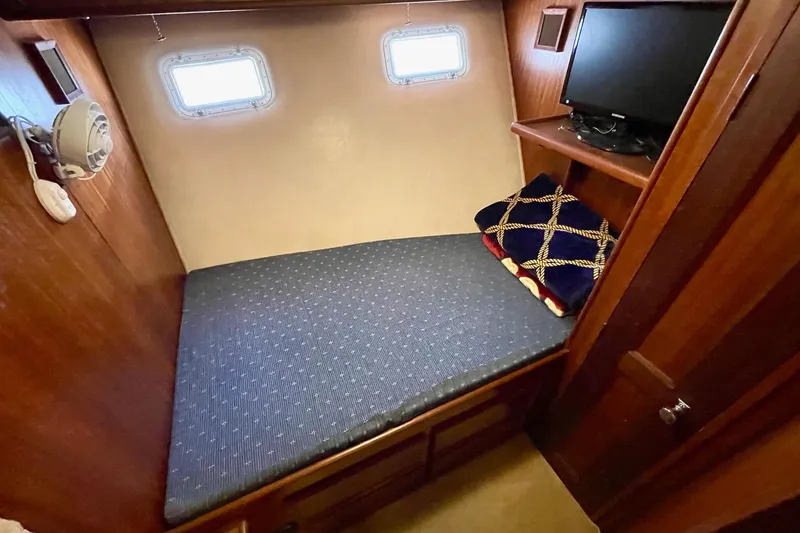 Slide: The Image of 1976 Hatteras 48 Long Range Cruiser cabin with bed, portholes, and TV. - 58
