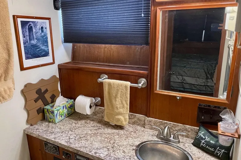 Slide: The Image of Bathroom interior of 1976 Hatteras 48 Long Range Cruiser with granite countertop and wooden accents. - 60