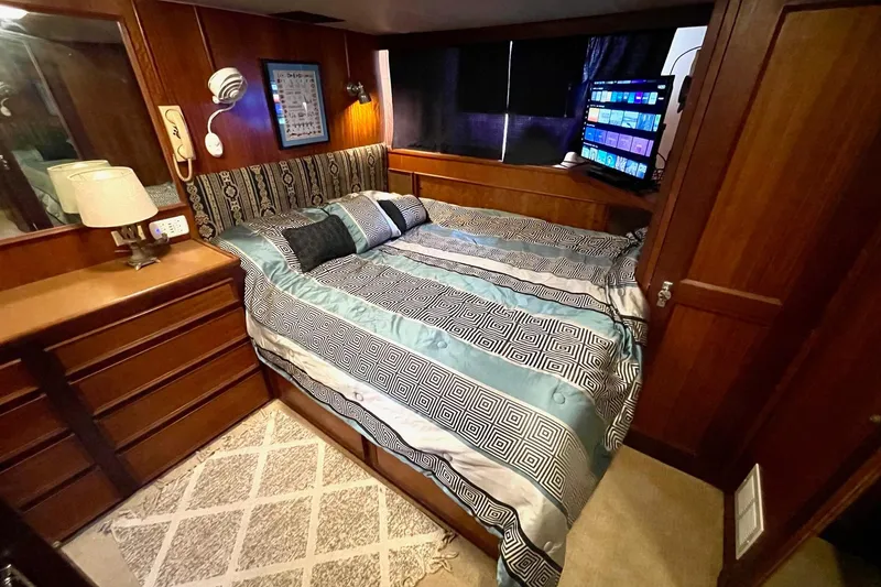 Slide: The Image of Cozy bedroom interior of 1976 Hatteras 48 Long Range Cruiser with wood paneling and modern amenities. - 63