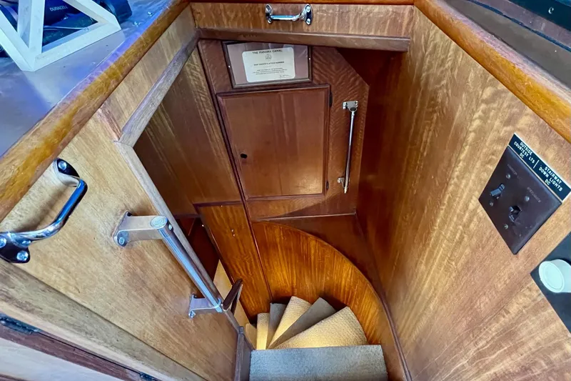 Slide: The Image of Interior staircase of 1976 Hatteras 48 Long Range Cruiser, featuring wooden paneling and carpeted steps. - 64