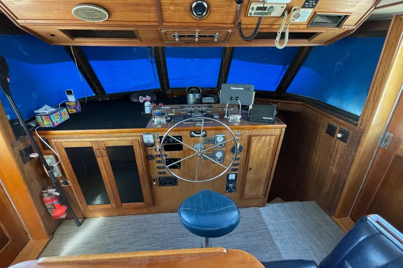 Slide: The Image of 1976 Hatteras 48 Long Range Cruiser helm with wooden dashboard and navigation equipment. - 66