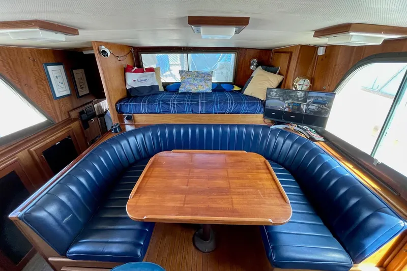 Slide: The Image of 1976 Hatteras 48 Long Range Cruiser interior with blue seating and wooden table. - 67