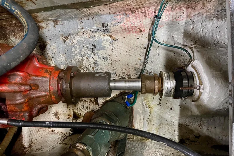 Slide: The Image of Engine room of 1976 Hatteras 48 Long Range Cruiser showing mechanical components and connections. - 75