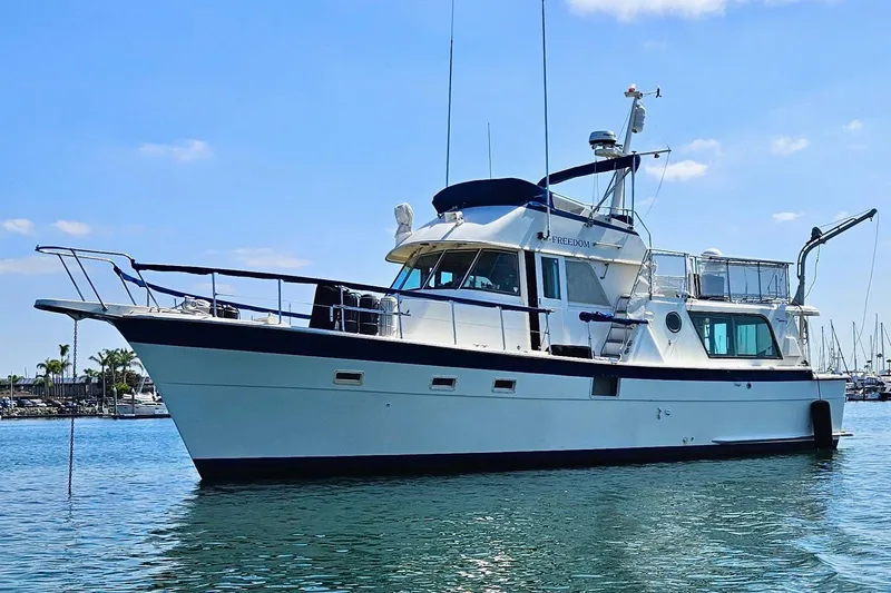 Slide: The Image of 1976 Hatteras 48 Long Range Cruiser yacht on calm water under blue sky. - 77
