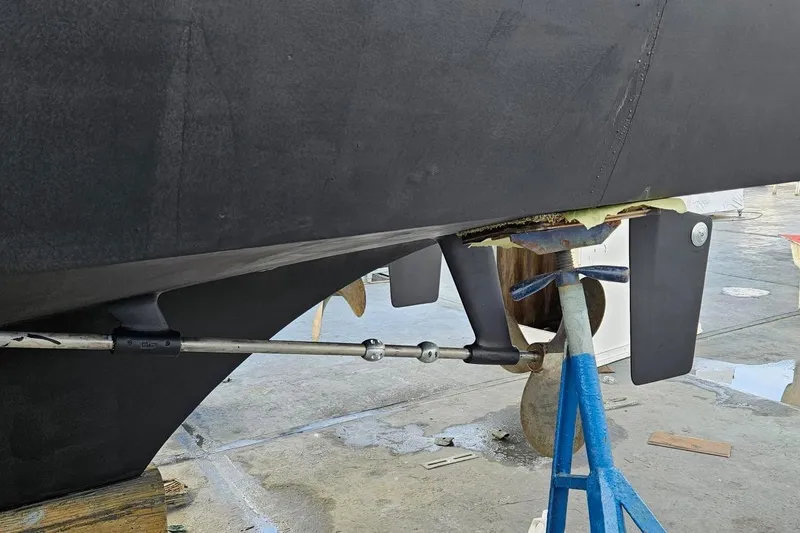 Slide: The Image of 1976 Hatteras 48 Long Range Cruiser hull on dry dock, showcasing propeller and rudder. - 79