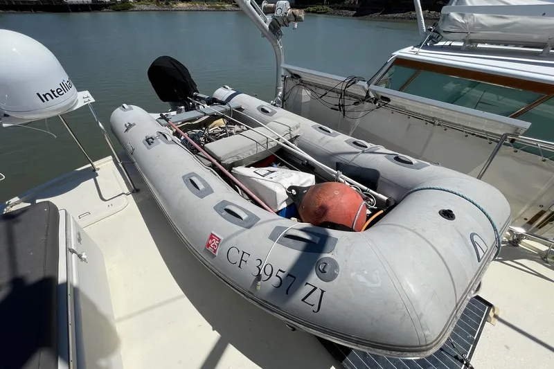 Slide: The Image of Inflatable dinghy on 1976 Hatteras 48 Long Range Cruiser, docked by the water. - 8