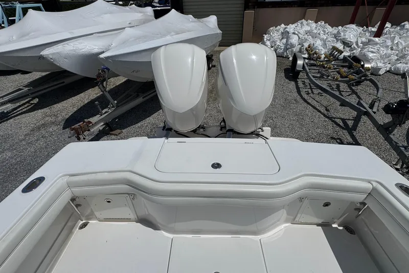 Slide: The Image of 2013 Jupiter 32 Cuddy boat with twin outboard engines, docked on gravel. - 11
