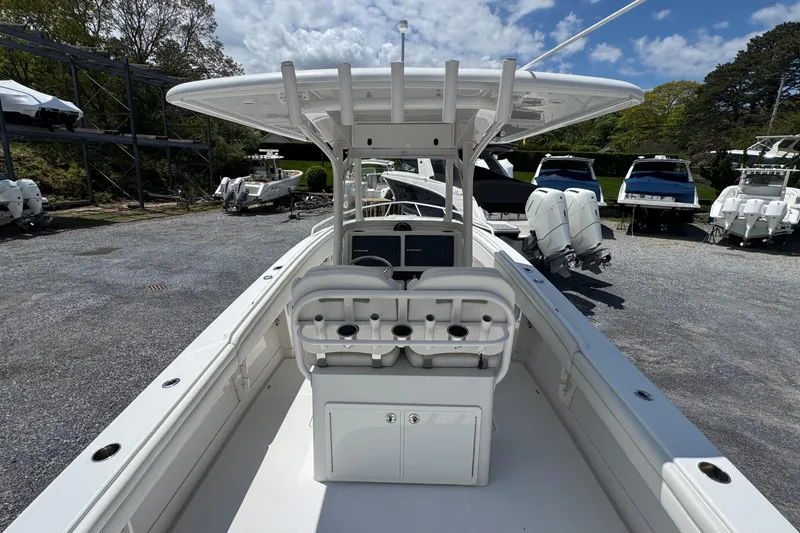 Slide: The Image of 2013 Jupiter 32 Cuddy boat with center console, docked in a marina under a cloudy sky. - 14