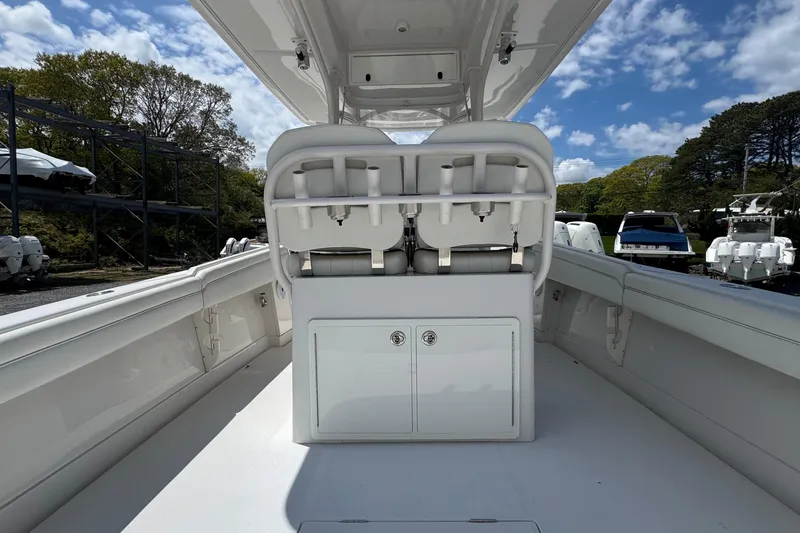 Slide: The Image of 2013 Jupiter 32 Cuddy boat interior with seating and storage, under a clear blue sky. - 15