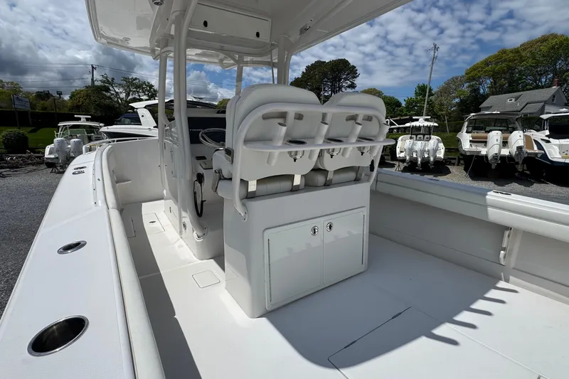 Slide: The Image of 2013 Jupiter 32 Cuddy boat interior with seating and storage, under a partly cloudy sky. - 16