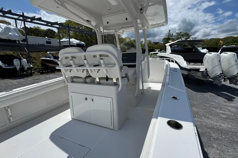 Slide: The Image of 2013 Jupiter 32 Cuddy boat interior with seating and console, parked outdoors. - 18