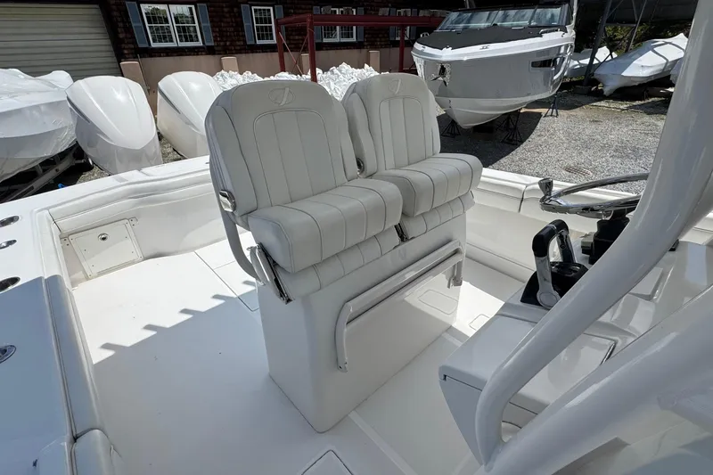 Slide: The Image of 2013 Jupiter 32 Cuddy boat interior with white seating and steering console. - 21