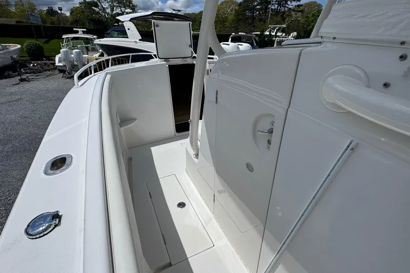Slide: The Image of 2013 Jupiter 32 Cuddy boat deck with sleek white finish and storage compartments. - 32