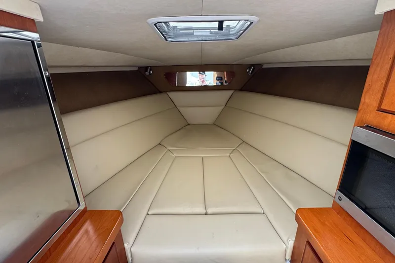 Slide: The Image of Interior of a 2013 Jupiter 32 Cuddy boat with beige seating and wood accents. - 35