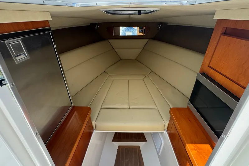 Slide: The Image of Interior of 2013 Jupiter 32 Cuddy boat with beige seating and wooden cabinetry. - 37