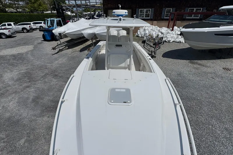 Slide: The Image of 2013 Jupiter 32 Cuddy boat in a marina, surrounded by other vessels and equipment. - 40