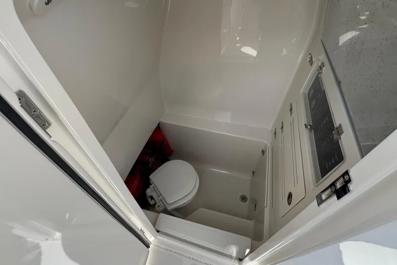Slide: The Image of Interior of 2013 Jupiter 32 Cuddy boat showing compact bathroom with toilet and storage. - 42
