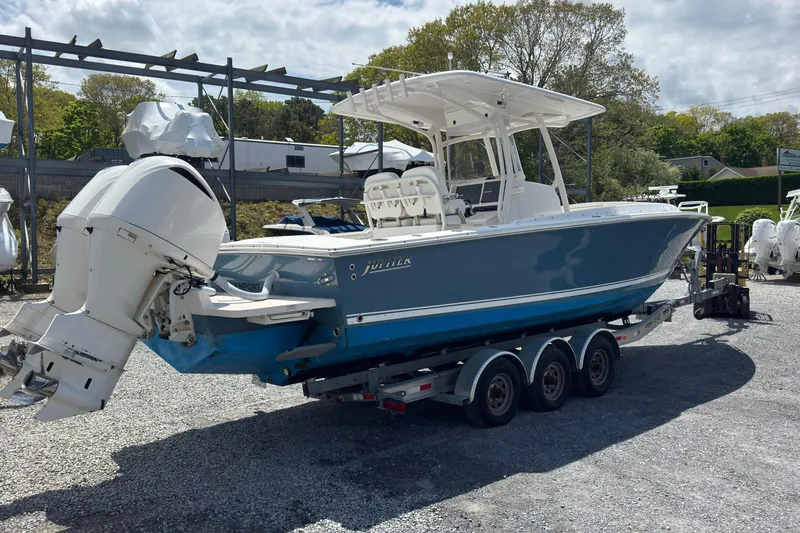 Slide: The Image of 2013 Jupiter 32 Cuddy boat on trailer, featuring dual outboard engines. - 5