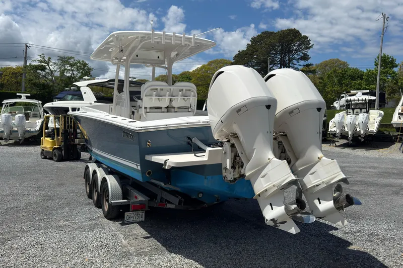 Slide: The Image of 2013 Jupiter 32 Cuddy boat with dual outboard motors on a trailer. - 7