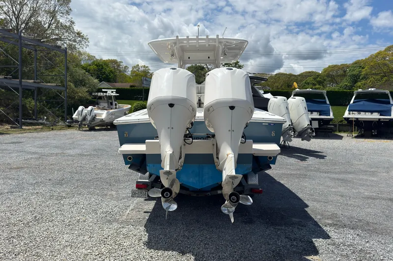 Slide: The Image of 2013 Jupiter 32 Cuddy boat with dual outboard engines in a marina setting. - 8