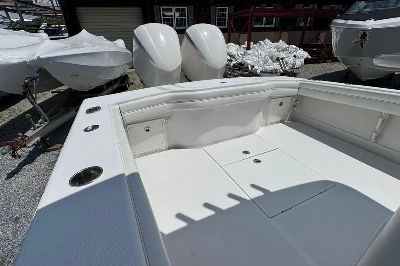 Slide: The Image of 2013 Jupiter 32 Cuddy boat deck with twin outboard engines in a marina setting. - 9