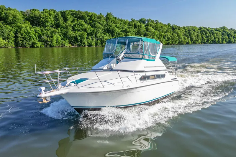 The Image of 1994 Carver 380 Santego cruising on a scenic river with lush green trees. - 1