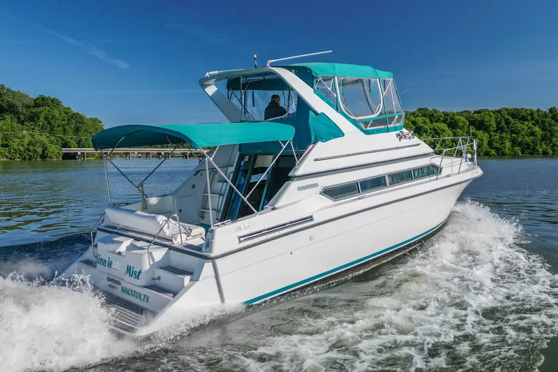 Slide: The Image of 1994 Carver 380 Santego yacht cruising on a scenic river under clear blue skies. - 8