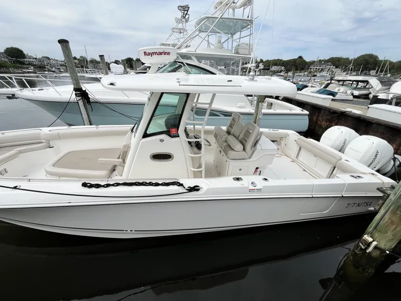 Slide: The Image of 2018 Boston Whaler 330 Outrage boat docked, featuring spacious seating and modern equipment. - 1