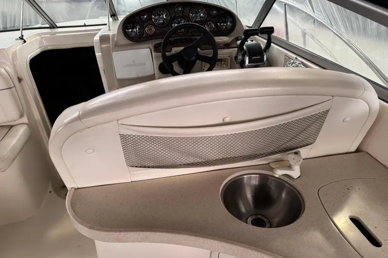 Slide: The Image of 2002 Rinker Fiesta Vee 310 boat interior with helm, steering wheel, and sink. - 10