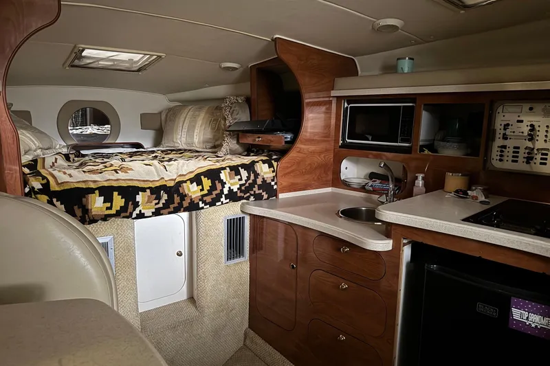 Slide: The Image of Interior of 2002 Rinker Fiesta Vee 310 boat with cozy bed and kitchenette. - 13