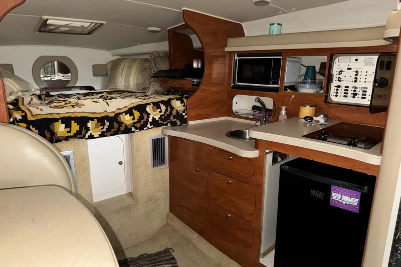 Slide: The Image of Interior of a 2002 Rinker Fiesta Vee 310 boat with kitchenette and cozy sleeping area. - 14