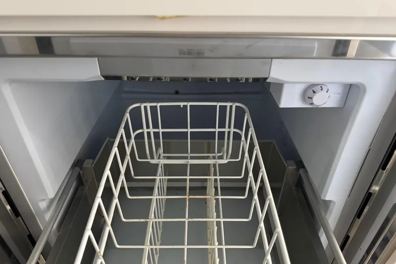 Slide: The Image of Open refrigerator with wire basket and adjustable temperature dial. - 18