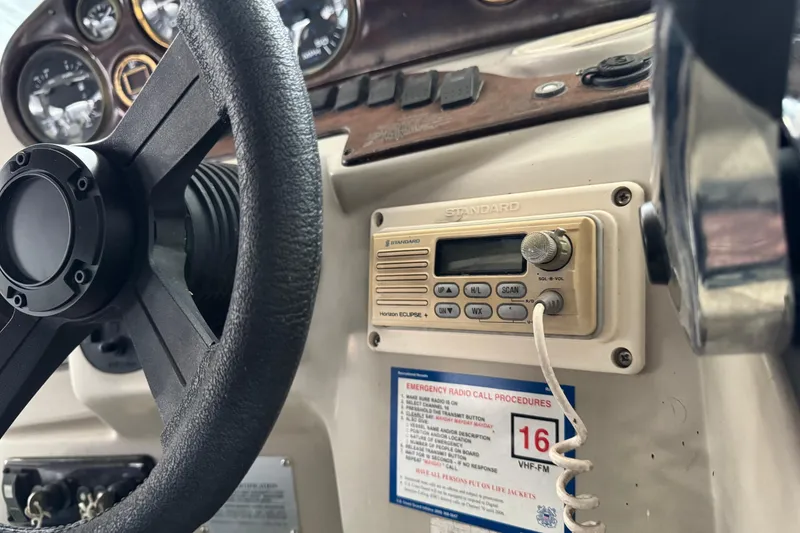 Slide: The Image of Steering wheel and radio controls on a 2002 Rinker Fiesta Vee 310 boat dashboard. - 4