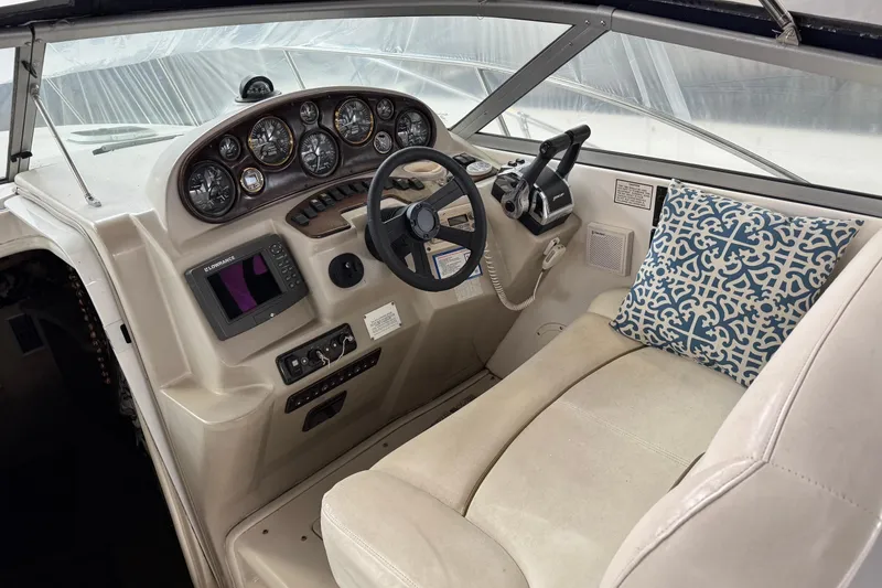 Slide: The Image of 2002 Rinker Fiesta Vee 310 boat cockpit with steering wheel, gauges, and patterned cushion. - 7